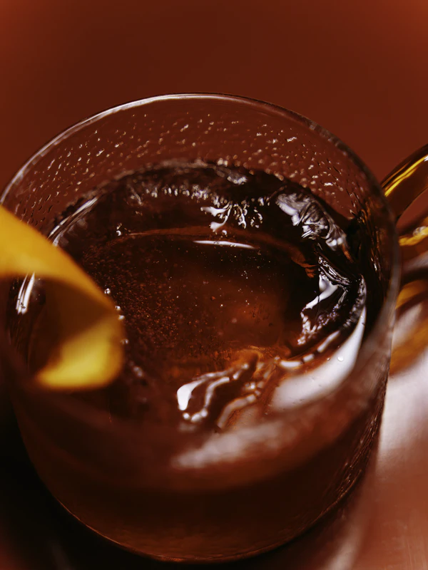 A red cocktail with an orange twist on a red table: dinner after a West End show